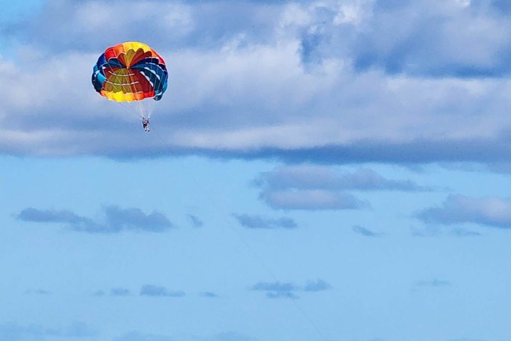a parachute is flying over a body of water